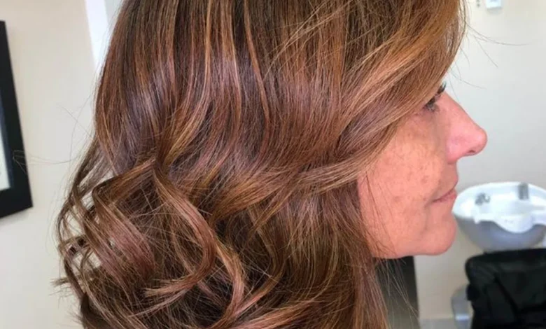 Cabelos iluminados em mulher madura com tons naturais de mel, caramelo e amĂȘndoa, realçando a beleza aos 50+.