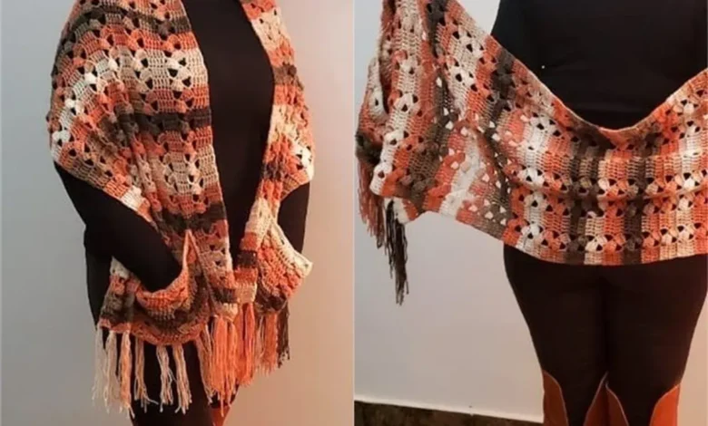 Cachecol de crochĂȘ em tons terrosos com franjas, usado sobre roupa preta.