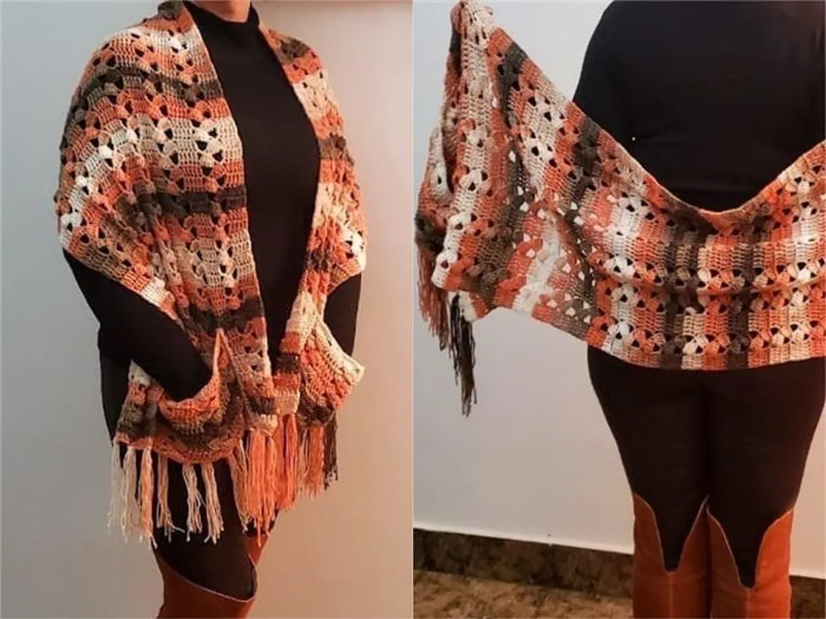 Cachecol de crochê em tons terrosos com franjas, usado sobre roupa preta.