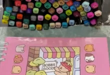 Canetas coloridas para arte e um caderno Bobbie Goods para pintura