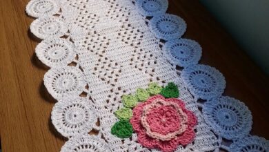 Caminho de mesa em crochê branco com flores rosas e detalhes em verde