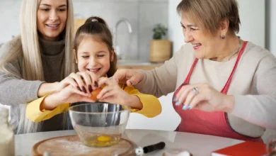 Criança, mãe e avó preparando uma receita juntas na cozinha, representando um momento especial para o Dia das Mães.