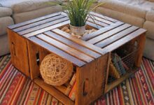 Mesa de centro feita com caixas de madeira recicladas, decorada com plantas e objetos criativos.