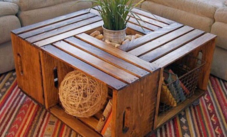 Mesa de centro feita com caixas de madeira recicladas, decorada com plantas e objetos criativos.