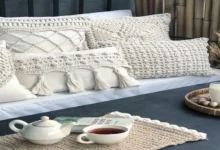 Almofadas e peças decorativas de crochê em tons claros em um ambiente aconchegante