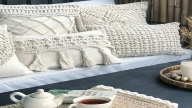 Almofadas e peças decorativas de crochê em tons claros em um ambiente aconchegante