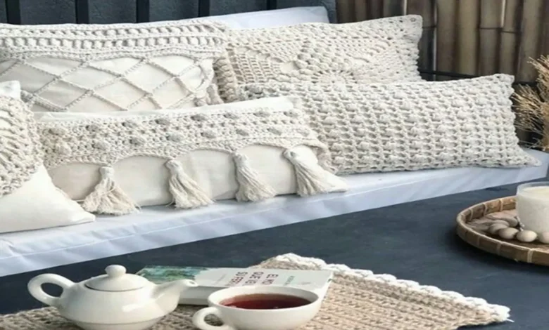 Almofadas e peças decorativas de crochê em tons claros em um ambiente aconchegante