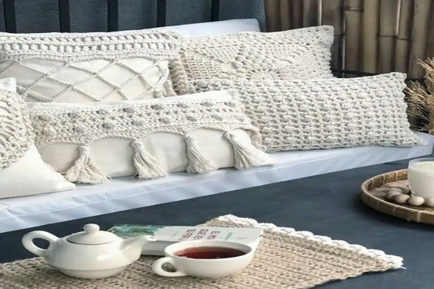 Almofadas e peças decorativas de crochê em tons claros em um ambiente aconchegante