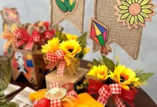 Decoração de mesa para festa de São João com arranjos de girassóis, bandeirinhas de juta, e detalhes em fita xadrez vermelho