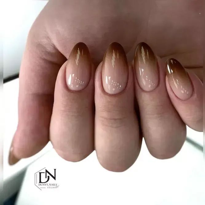 Unhas decoradas com efeito degradê em tons terrosos, do nude ao marrom, criando um visual suave e sofisticado.