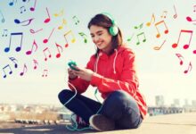 Jovem ouvindo música com fones de ouvido e sorrindo ao ar livre