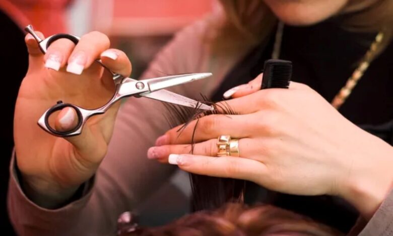 Cabeleireira cortando cabelo com tesoura profissional