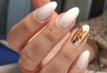 Unhas ovais com esmalte branco e decoração dourada no estilo manicure italian