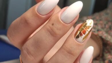 Unhas ovais com esmalte branco e decoração dourada no estilo manicure italian