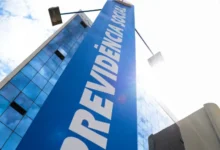 Fachada do prédio da Previdência Social com céu azul ao fundo.