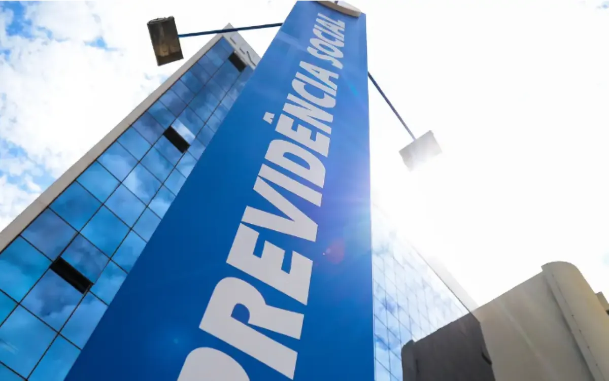 Fachada do prédio da Previdência Social com céu azul ao fundo.