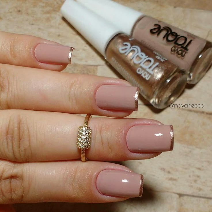 Unhas com francesinha metálica, com acabamento nude e detalhes dourados nas pontas, criando um estilo moderno e sofisticado.