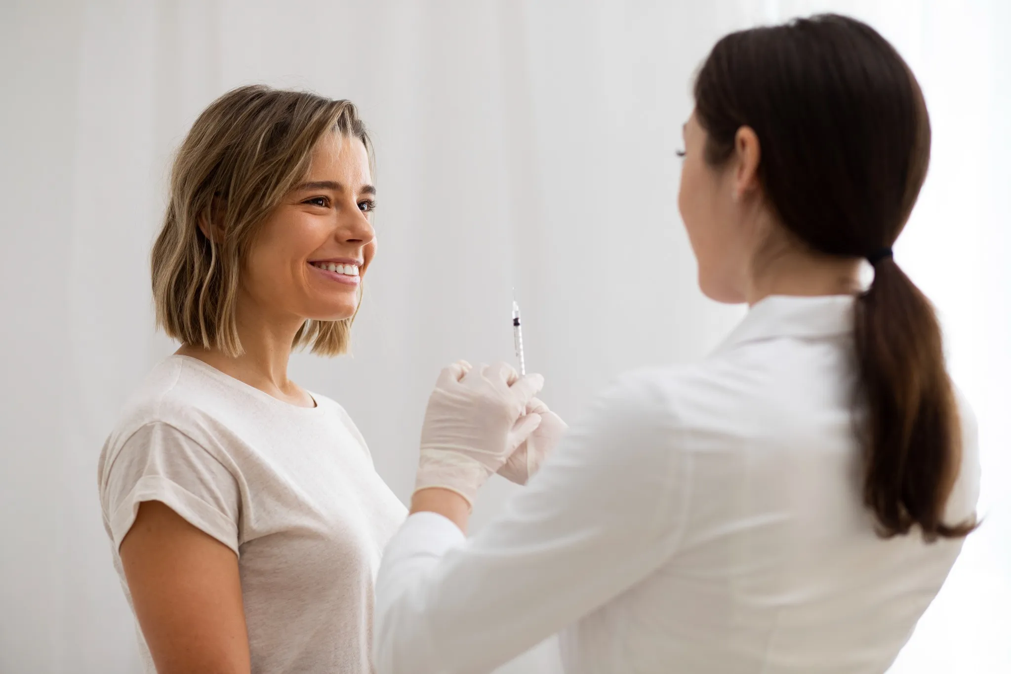 Profissional segurando seringa para aplicação de procedimento estético