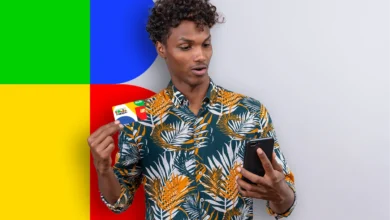 Ícone amarelo com a mensagem "Enviado para crédito em conta" no cartão do Bolsa Família, mostrado em mãos de homem usando camisa estampada.