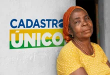 Idosa sorridente com lenço laranja e blusa amarela ao lado do logo do Cadastro Único