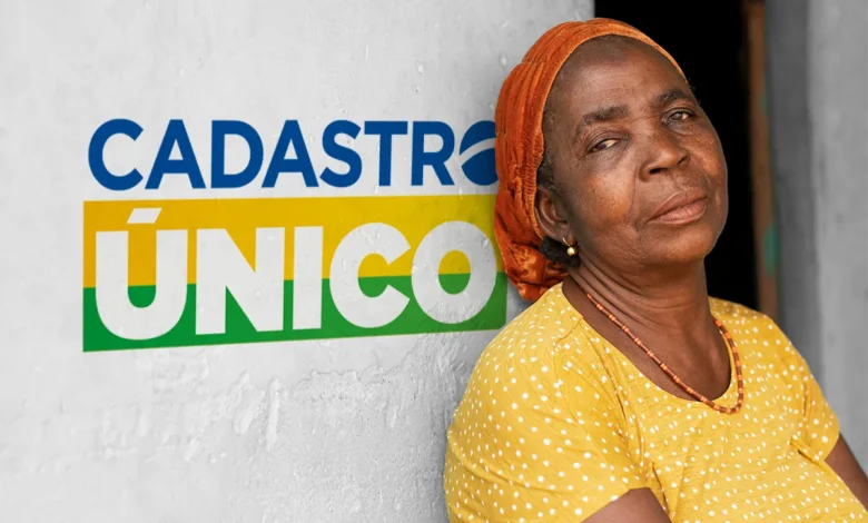 Idosa sorridente com lenço laranja e blusa amarela ao lado do logo do Cadastro Único