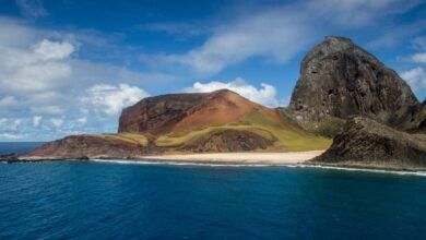 Vista da Ilha de Trindade, com seus imponentes montes e águas cristalinas do oceano Atlântico.