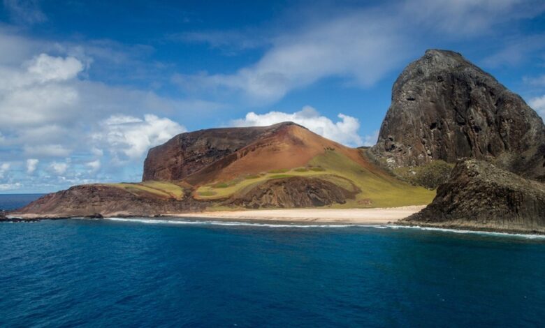 Vista da Ilha de Trindade, com seus imponentes montes e águas cristalinas do oceano Atlântico.