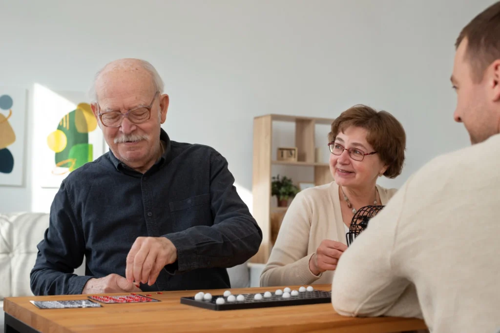 Pessoas idosas jogando jogos de tabuleiro, concentradas e sorrindo em um ambiente interno.