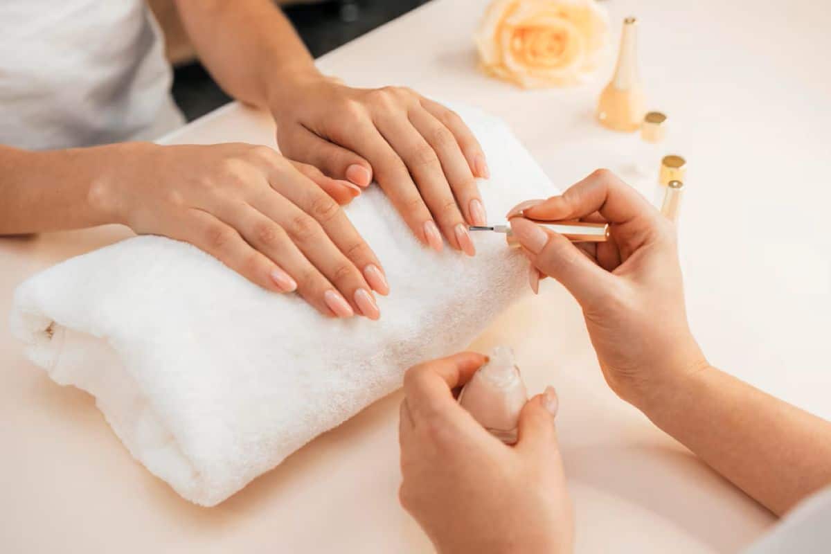 Mulher fazendo as unhas em salão de beleza, representando cuidados com unhas decoradas em gel para mulheres acima de 50 anos
