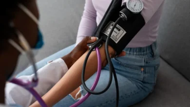 Profissional de saúde medindo a pressão arterial de uma paciente durante atendimento.