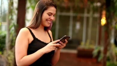 Mulher feliz lendo mensagem de fim de semana no celular ao ar livre