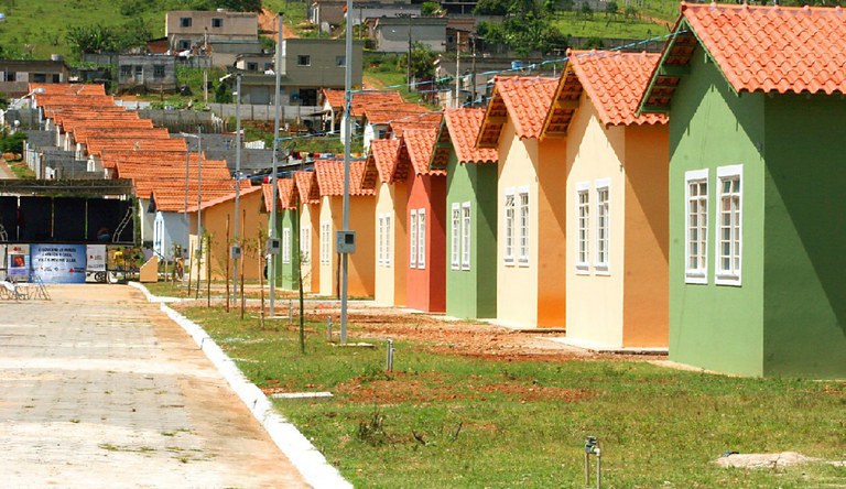 Fila de casas coloridas construídas pelo programa Minha Casa Minha Vida em área residencial