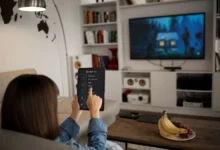 Jovem mulher controlando TV inteligente com tablet em sala moderna