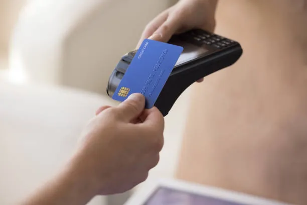 Pessoa usando cartão de crédito em uma máquina de pagamento eletrônico