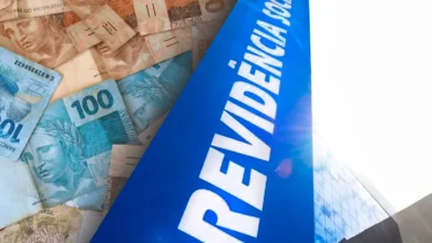 Fachada da Previdência Social ao lado de várias cédulas de reais, ilustrando o pagamento do 13º salário do INSS.