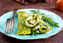 Panquecas verdes com recheio cremoso de queijo e espinafre em prato azul