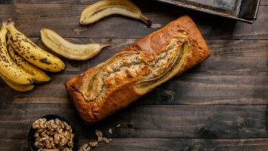 Pão de banana caseiro com bananas maduras e nozes sobre mesa rústica de madeira