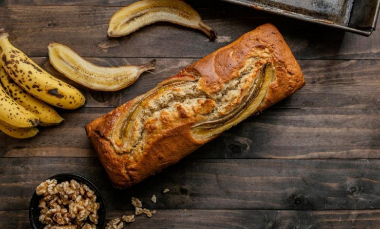 Pão de banana caseiro com bananas maduras e nozes sobre mesa rústica de madeira