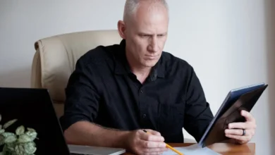 Homem concentrado analisando documentos financeiros com laptop ao lado, simbolizando planejamento financeiro para aposentados em 2025.
