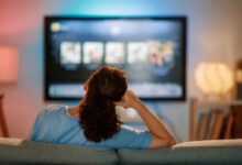 Mulher assistindo novelas turcas em plataformas de streaming na televisão em casa