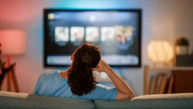 Mulher assistindo novelas turcas em plataformas de streaming na televisão em casa