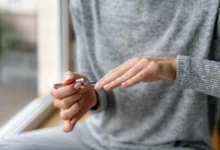 Uma pessoa aplicando um produto fortalecedor de unhas durante o processo de manicure, com foco em unhas naturais e saudáveis.