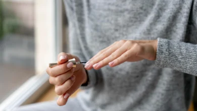 Uma pessoa aplicando um produto fortalecedor de unhas durante o processo de manicure, com foco em unhas naturais e saudáveis.