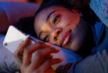 Mulher deitada sorrindo ao ler mensagem amorosa no celular