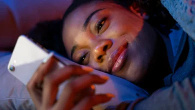 Mulher deitada sorrindo ao ler mensagem amorosa no celular