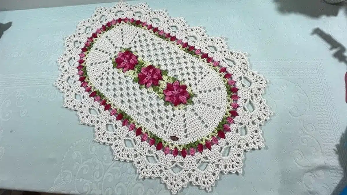 Tapete Maria com flor e tulipa em crochê, com detalhes em rosa e verde, ideal para decorar sua casa com sofisticação