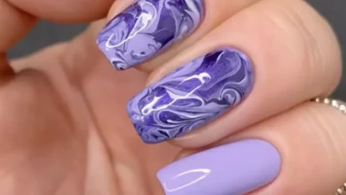 Unhas decoradas com efeito marmorizado nas cores roxas, ilustrando o tutorial de como fazer esse tipo de decoração.