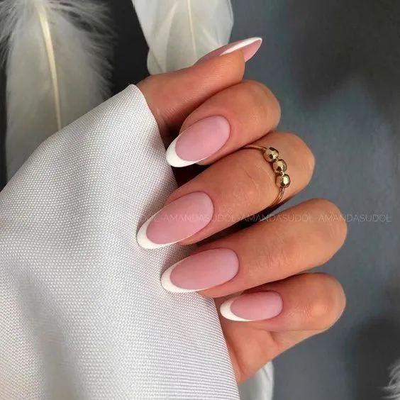 Unhas com formato oval e acabamento em francesinha branca.
