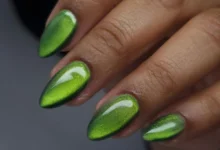 Unhas decoradas com efeito cat eye verde e acabamento brilhante.