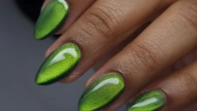 Unhas decoradas com efeito cat eye verde e acabamento brilhante.